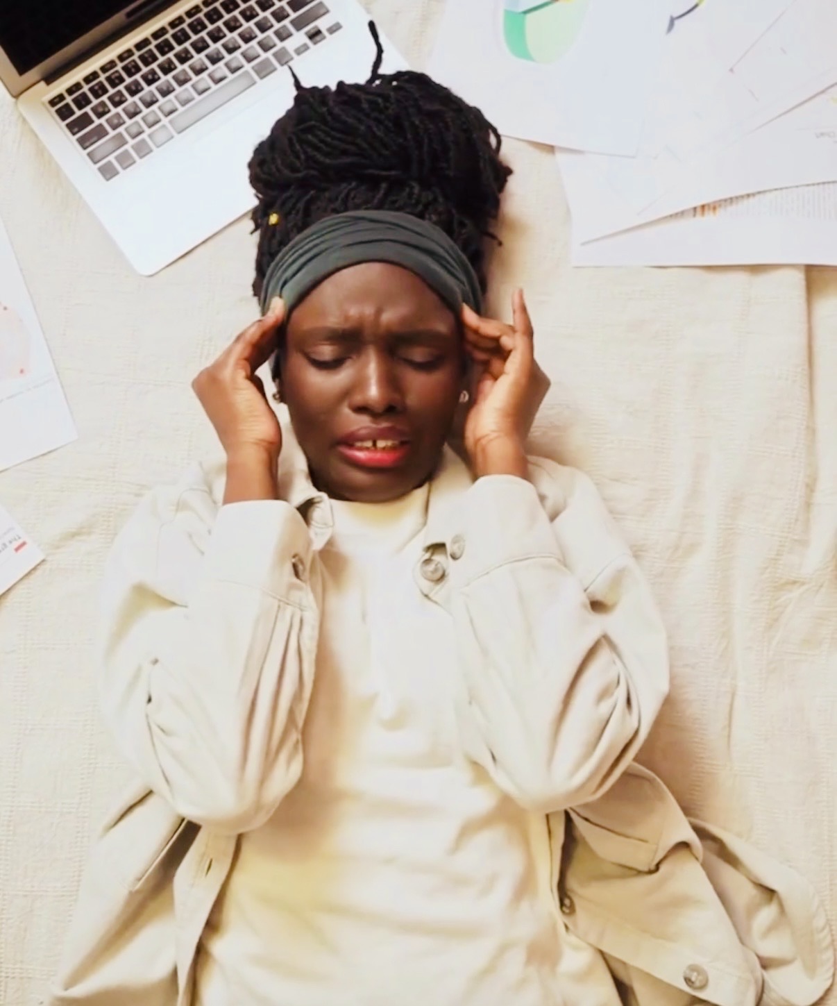 Women overwhelmed while planning international travel with documents and laptop